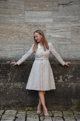 a lady in a tweed dress with a belt